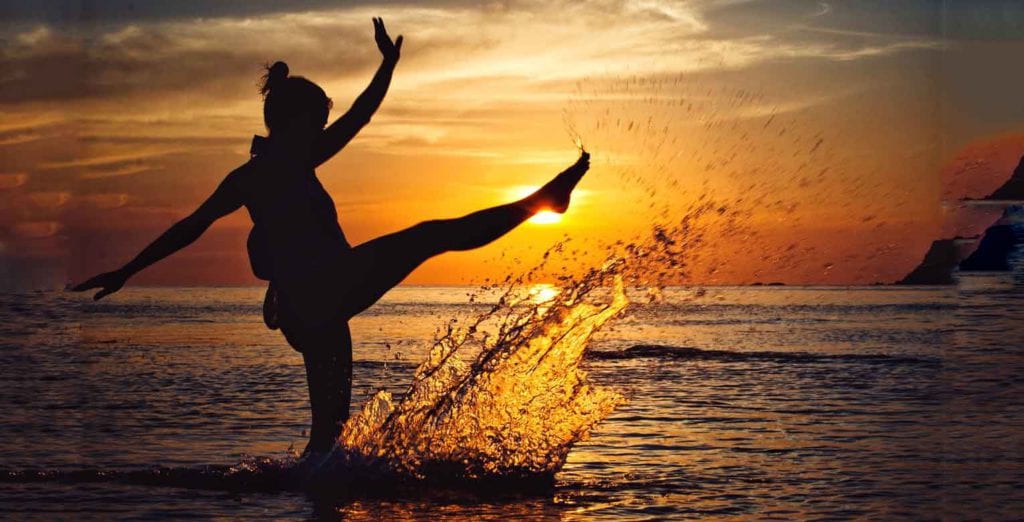 woman splashing water in the sunset