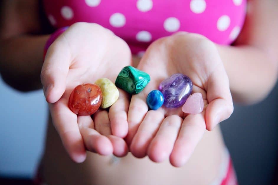 woman holding multicoloured gemstones