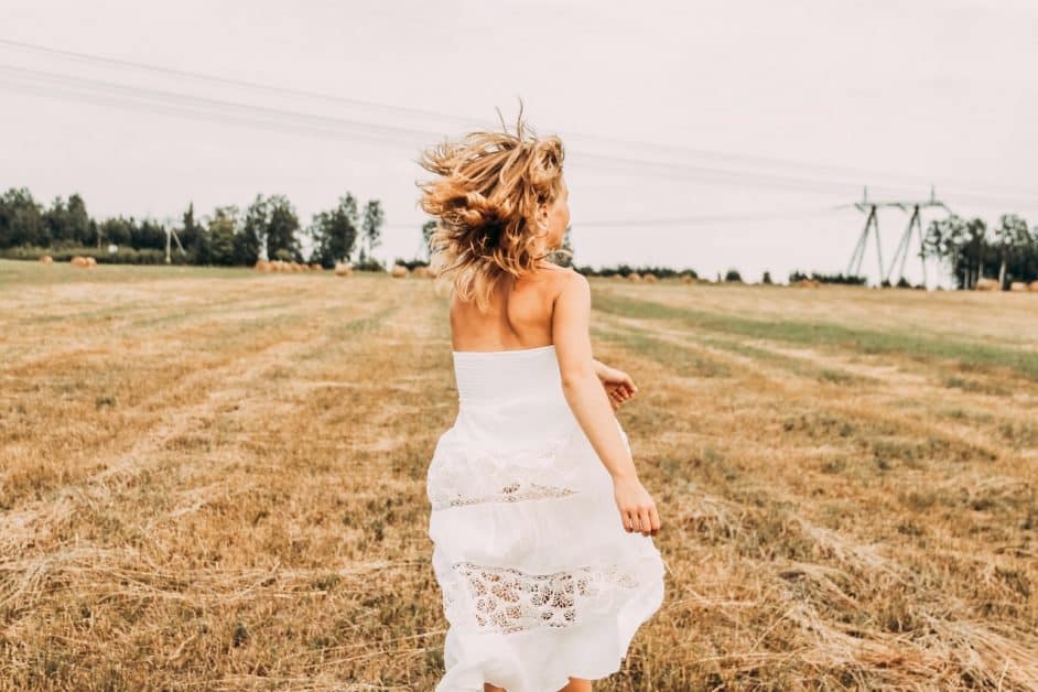 Moving forward with energy and excitement, like this woman running through a field in a white dress...