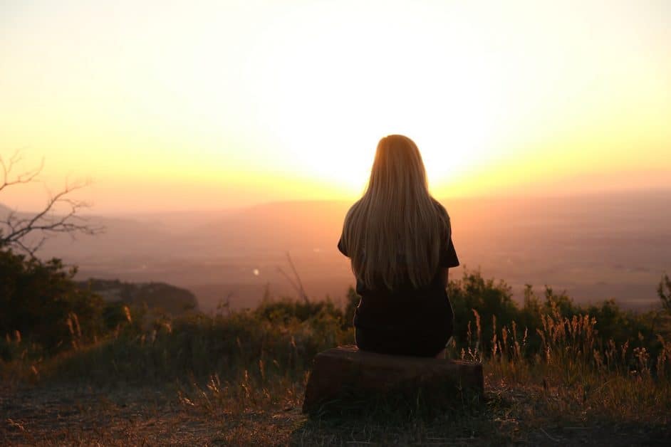 Sitting watching the sunset, like this woman, can help you turn negative to positive