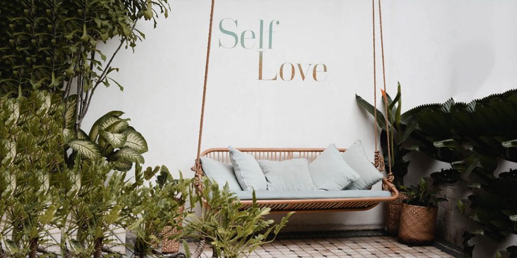 outdoor sofa wit self love written on the wall