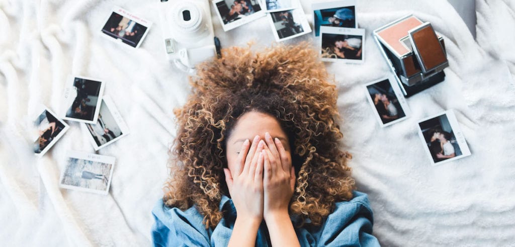 woman surrounded by polaroid images covering her face