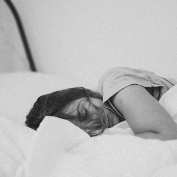 woman sleeping in white sheets