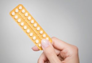 woman holding the contraceptive pill