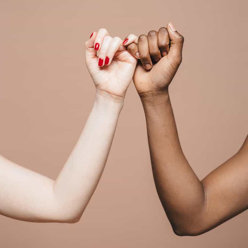 arms of two women holding hands