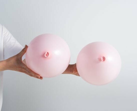 hands holding two balloons like breasts