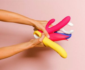 hands holding a variety of dildos