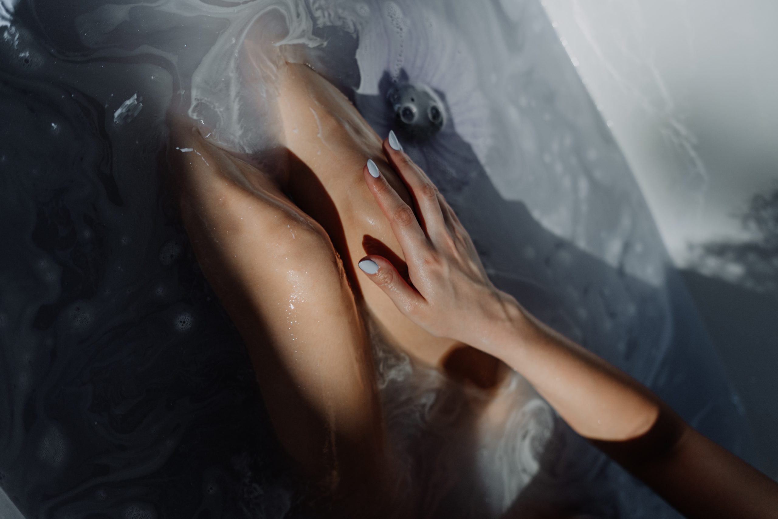 woman touching her leg in bath