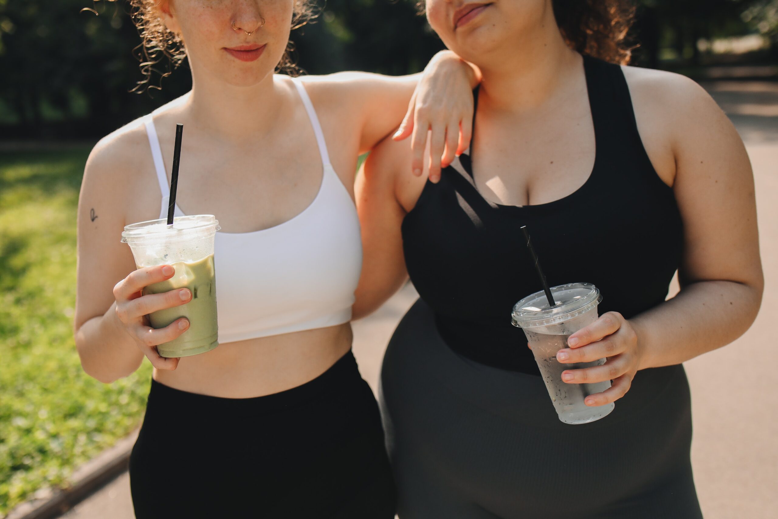 women in workout clothes holding a drink
