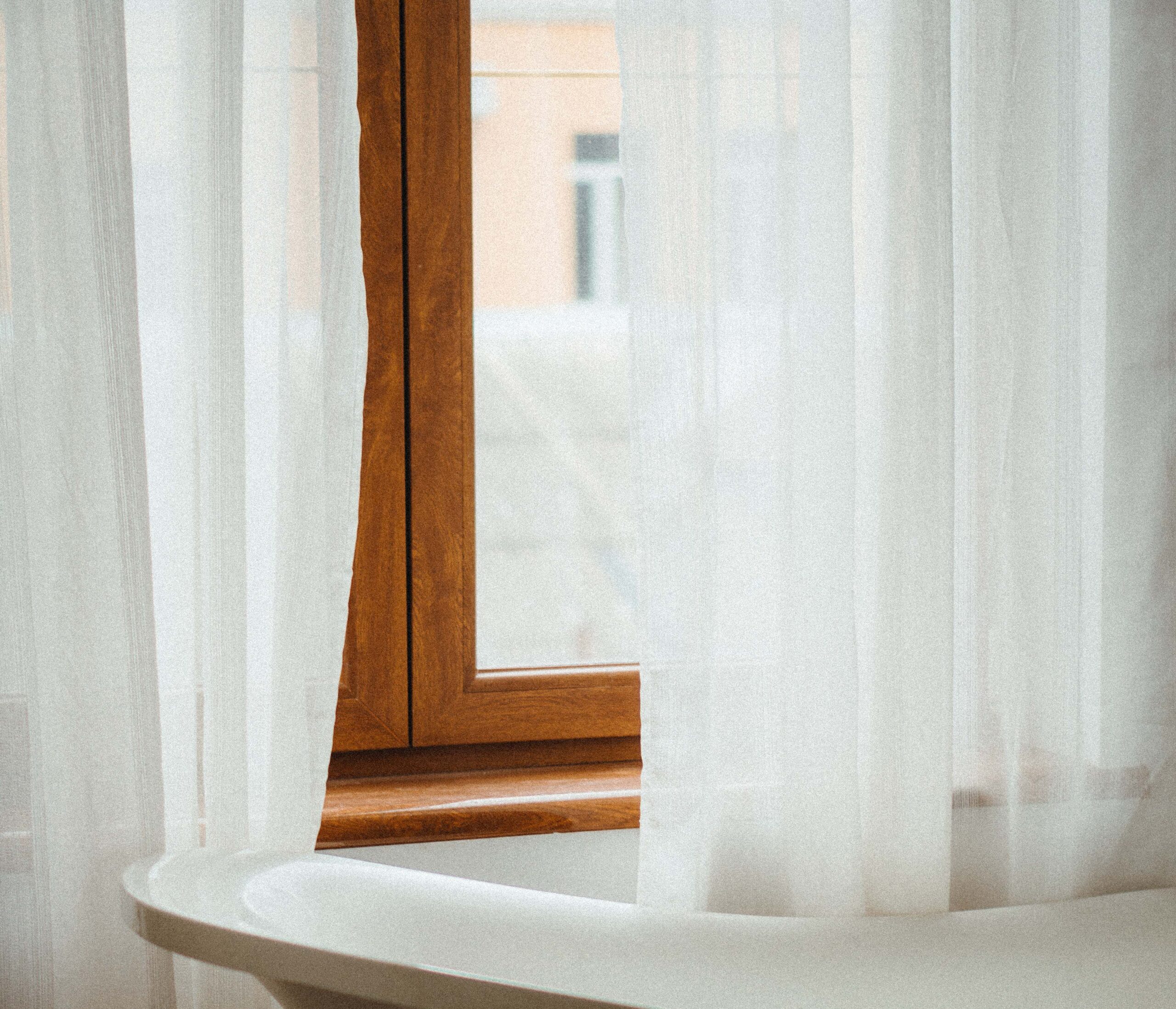 wood window and sheet curtains